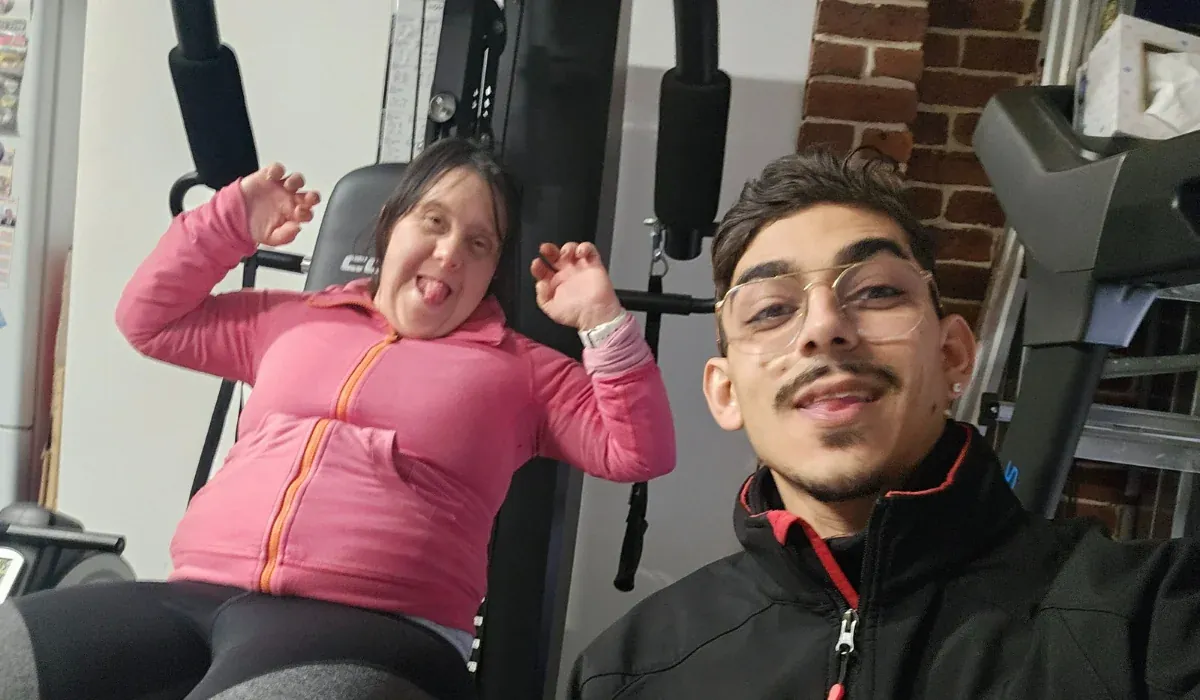 Accredited Exercise Physiologist Christopher Kondos taking a cheerful selfie with a client at a gym.