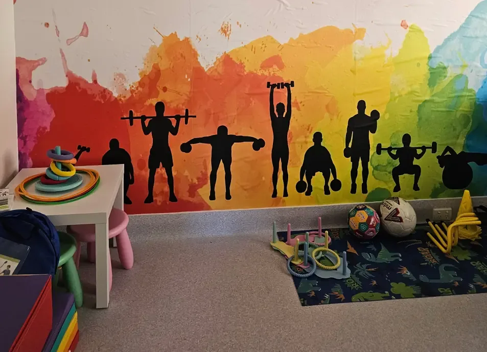 Paediatric exercise room with colourful mural and children's equipment